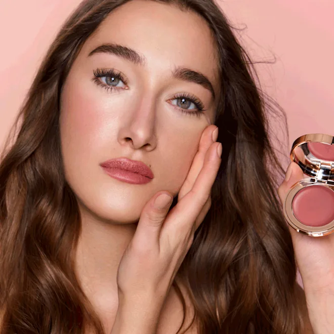 ragazza che applica il blush in crema di Charlotte Tilbury PILLOW TALK LIP & CHEEK GLOWCOLOUR OF DREAMS