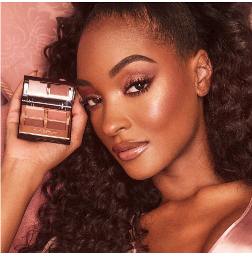 ragazza afro che tiene in mano la mini palette makeup di charlotte tilbury 