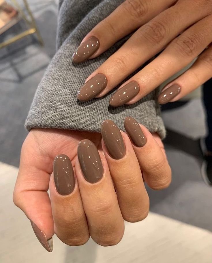 primo piano su mani con unghie smaltate con smalti colore mocha mousse