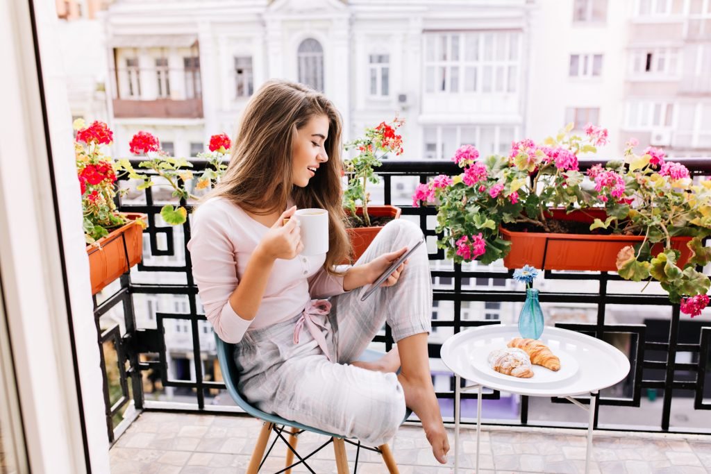 ragazza che si rilassa in un balcone fiorito