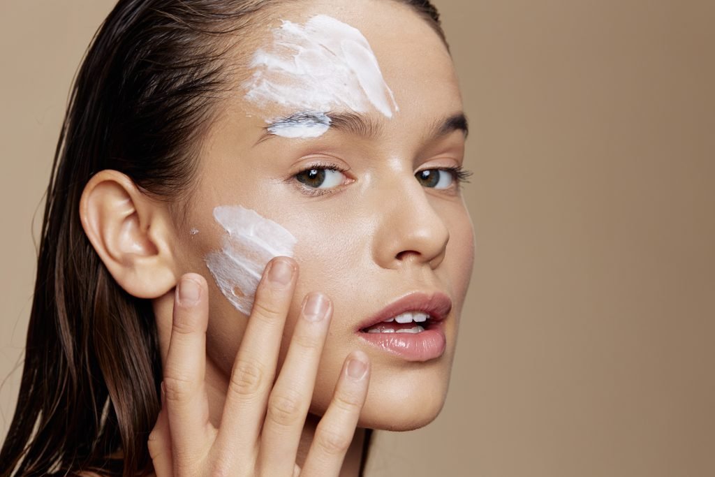 ragazza che usa una crema viso per l'estate