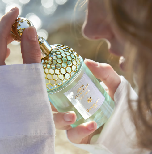 donna che tiene in mano e osserva in primo piano Guerlain Aqua Allegoria Rosa Verde – Eau de Toilette