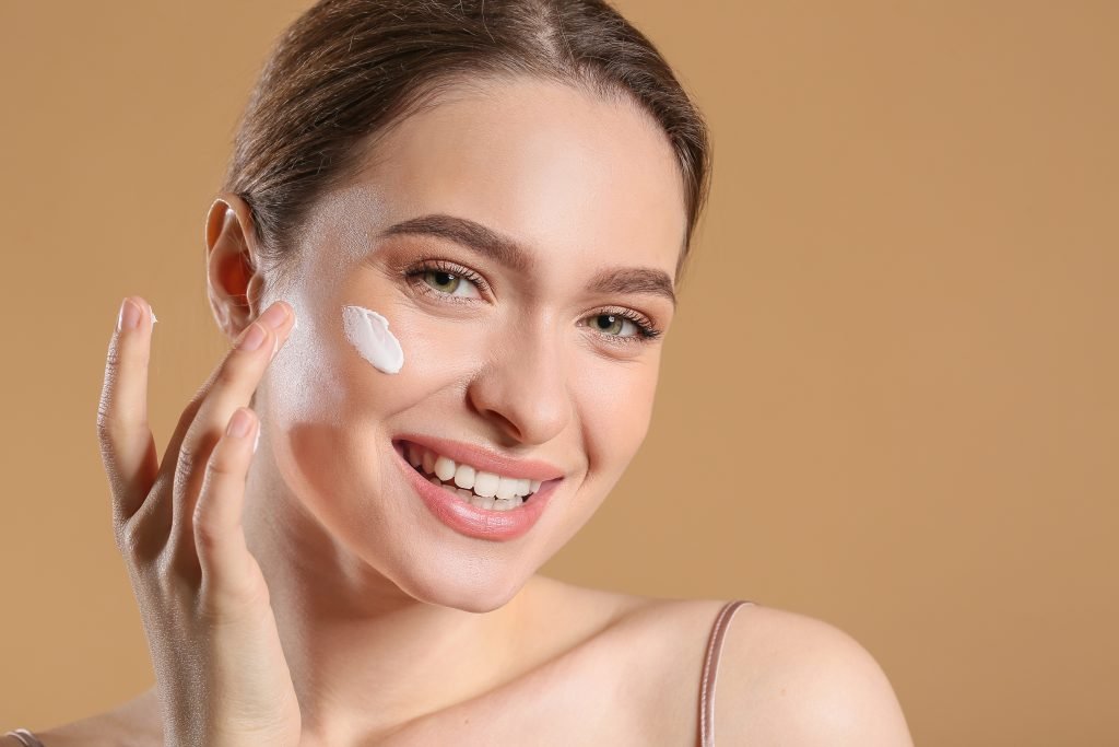 ragazza che usa una crema viso per l'estate