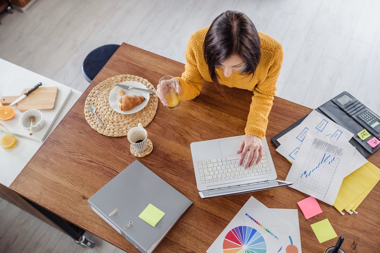 donna che fa colazione mentre lavora al pc - concetto di abitudini che ti cambiano la vita 