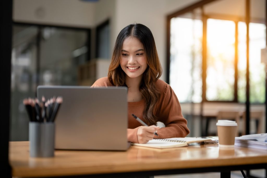 Concetto di COME ESSERE PIU PRODUTTIVI ragazza sorridente che lavora al pc in ufficio 