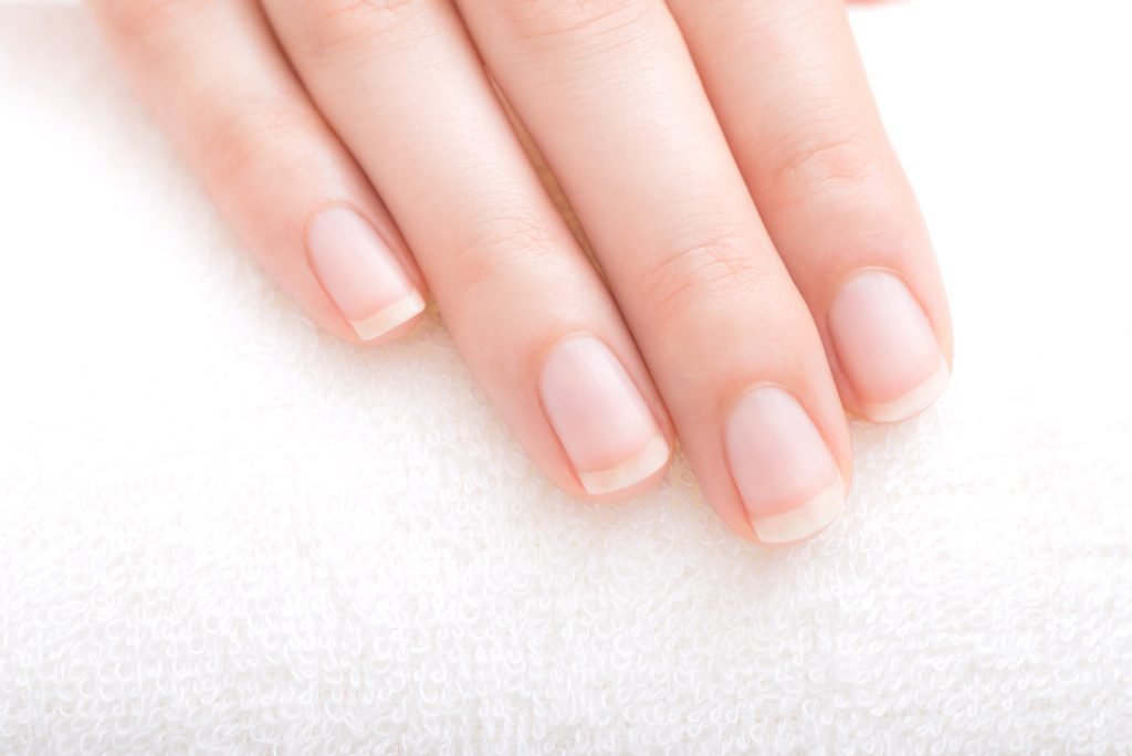 mano con unghie curate corte con french manicure 