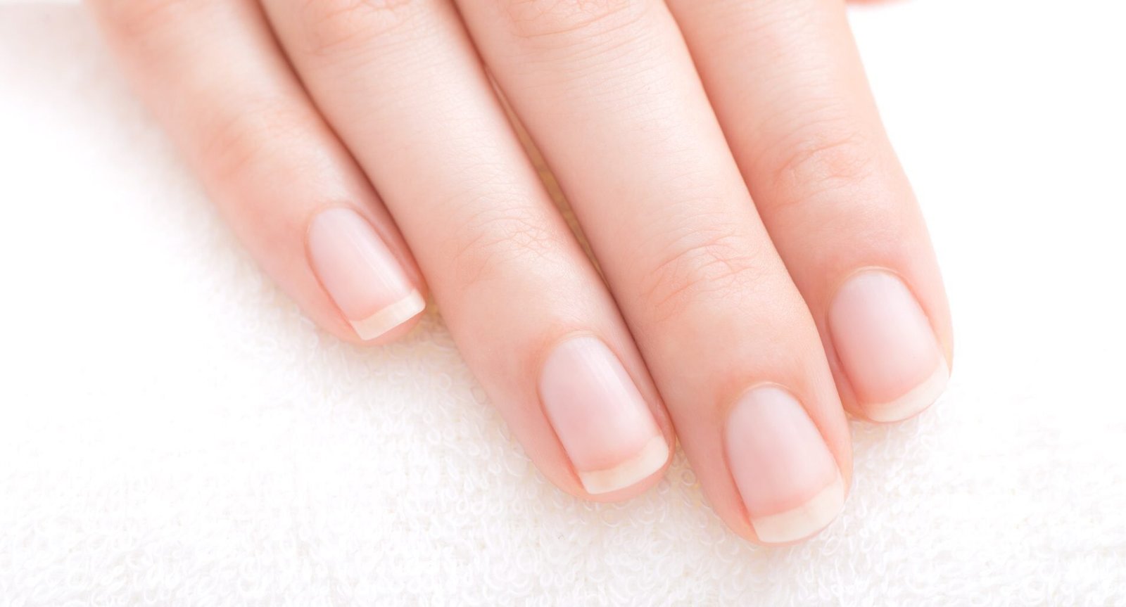 mano con unghie curate corte con french manicure. concetto di cura delle unghie ingiallite