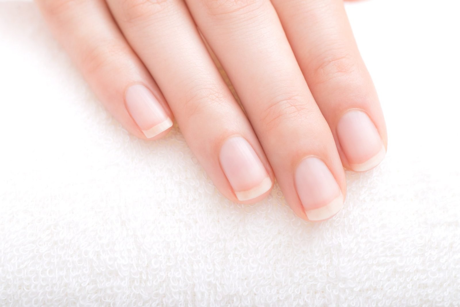 mano con unghie curate corte con french manicure- concetto di unghie e carenze nutrizionali e di mani e carenze nutrizionali