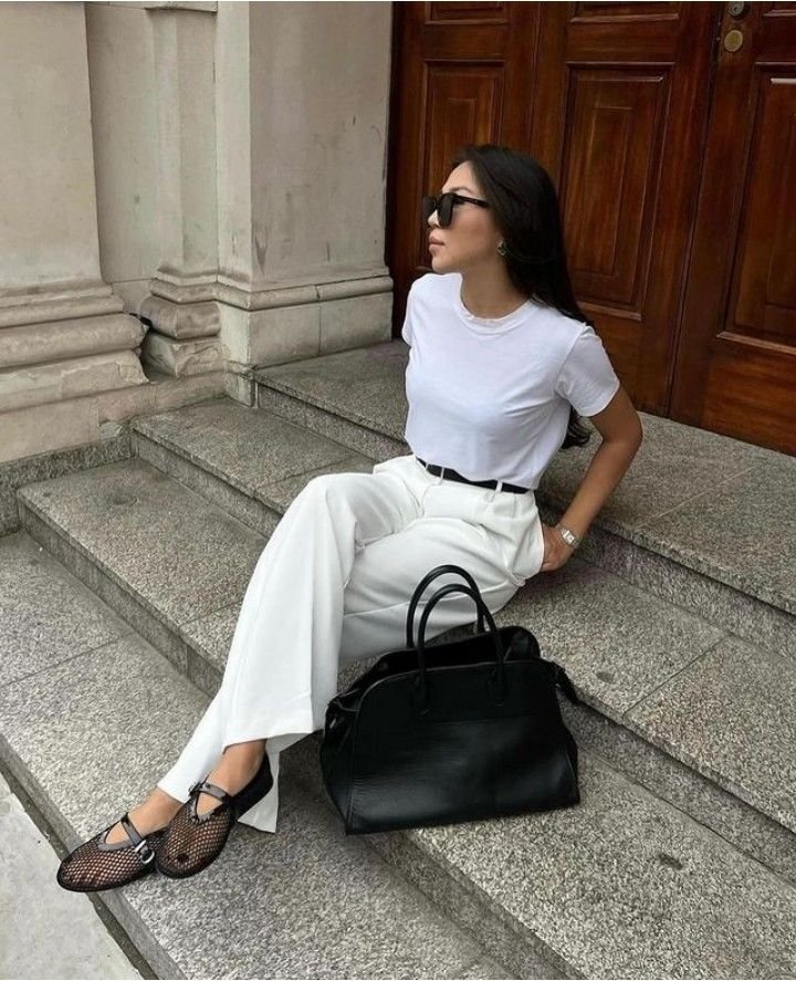 donna seduta per strada su dei gradini in marmo con outfit bianco e ballerine in rete economiche 