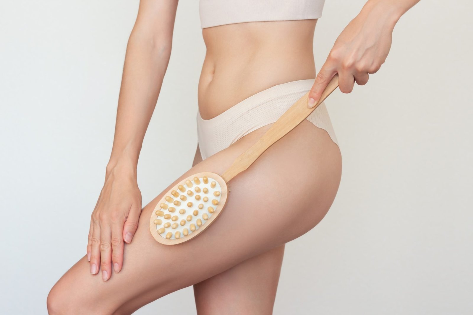 vista ritagliata di una donna ìche massaggia la gamba con una spazzola mostrando spazzolatura a secco come si fa 