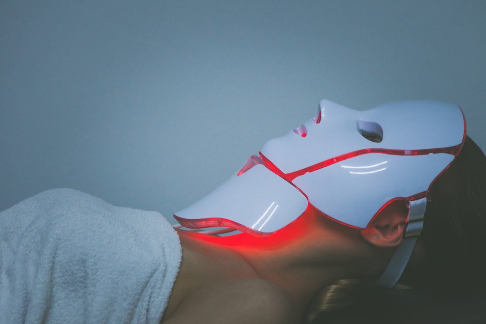 donna che sdraiata sul letto prova trattamento led viso - concetto maschere led viso funzionano davvero ?