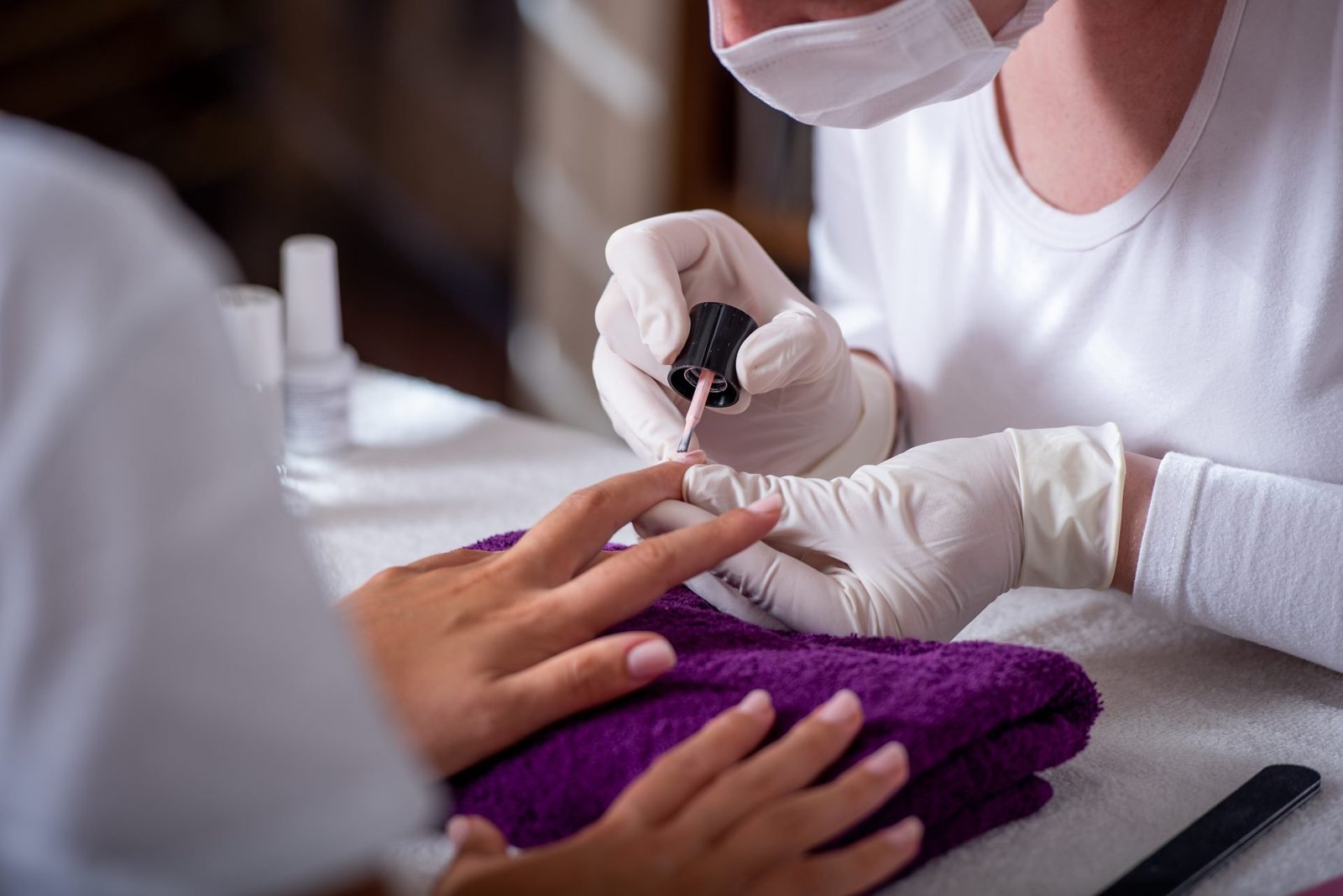 estetista mentre fa una manicure professionale con smalti privi di TPO e dmta