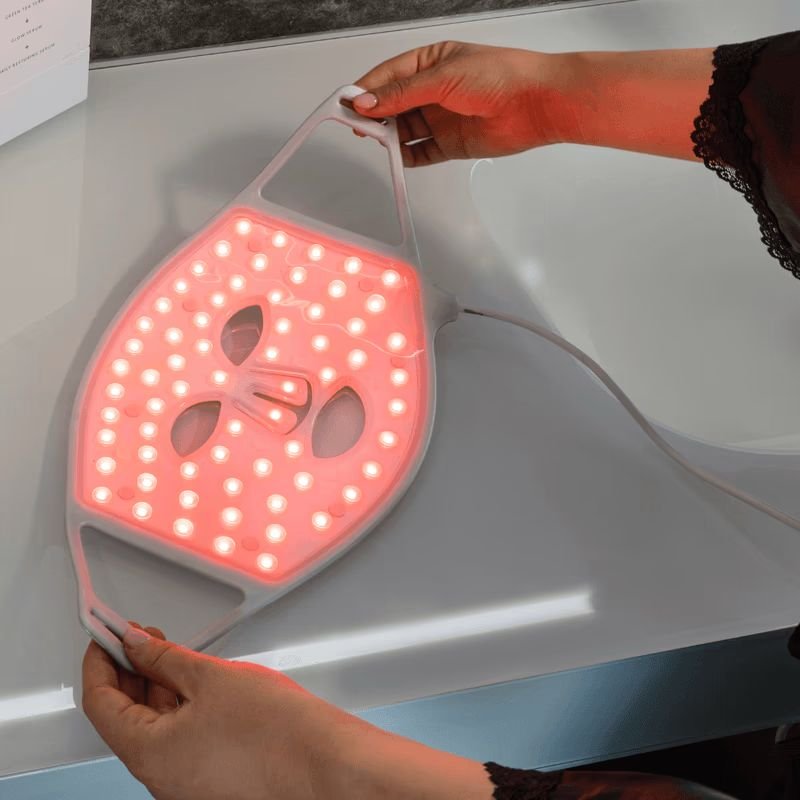 primo piano su mani di donna che si appresta a indossare la maschera led viso - concetto di maschere LED viso funzionano davvero ?