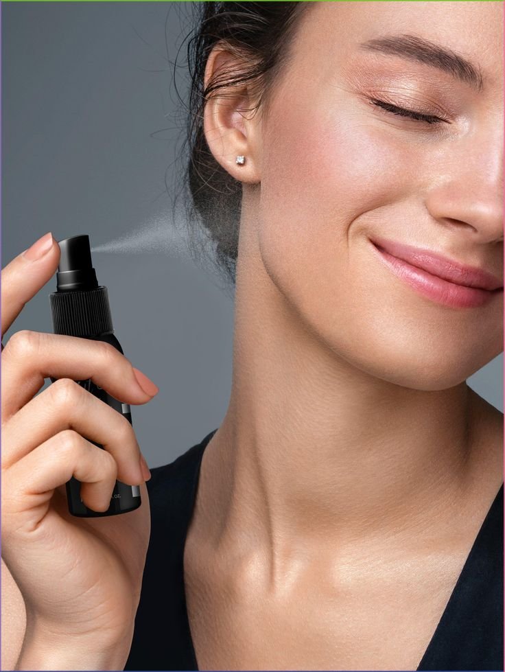 ragazza che si spruzza sul viso uno spray fissante makeup . Concetto fissatore trucco spray come si usa