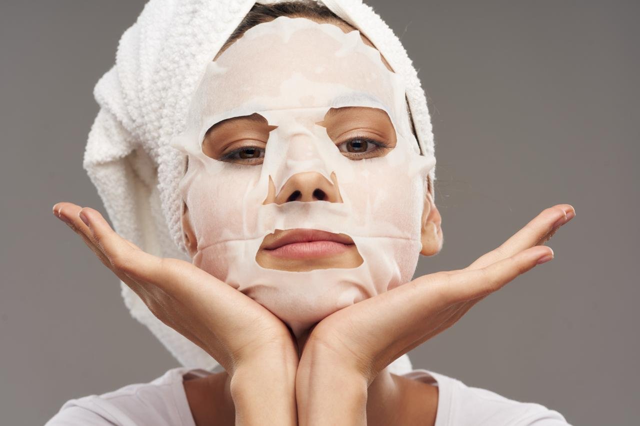 primo piano di ragazza che ha applicato una maschera in tessuto per il viso 