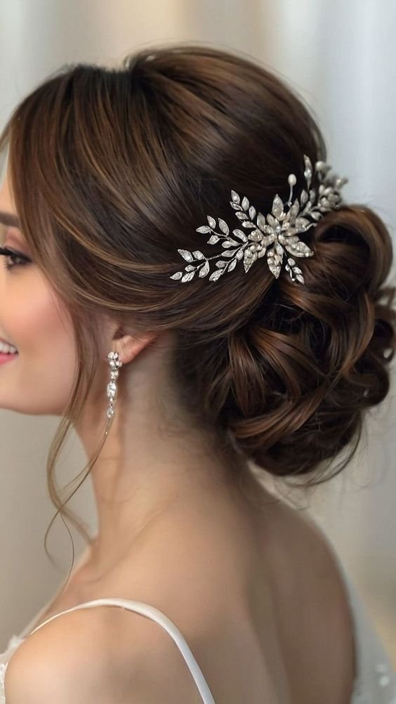 acconciature natalizie semplici: capelli mossi raccolti in chignon con fermagli di strass