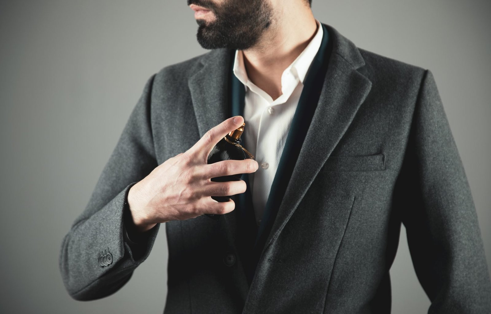 uomo in abito si spruzza un profumo. Tema miglori profumi uomo da regalare a san valentino