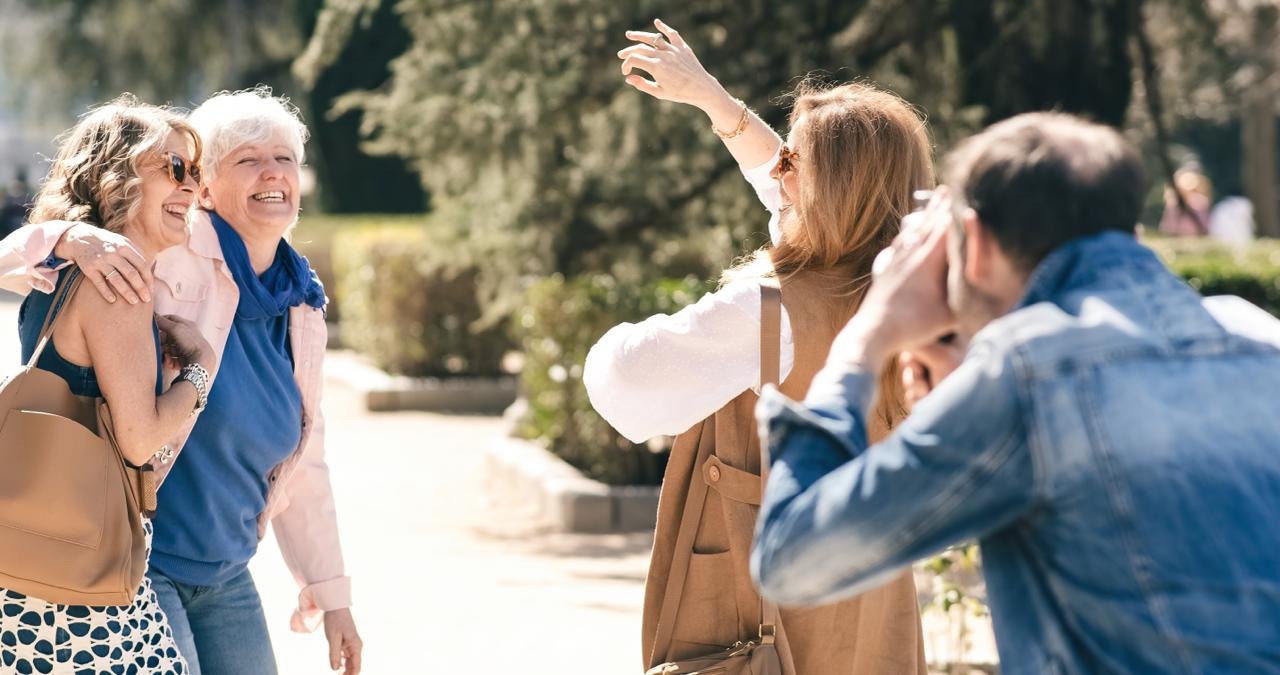 concetto di Come socializzare dopo i 50 anni . Gruppo di persone mature al parco sorride e si diverte mentre viene fotografata