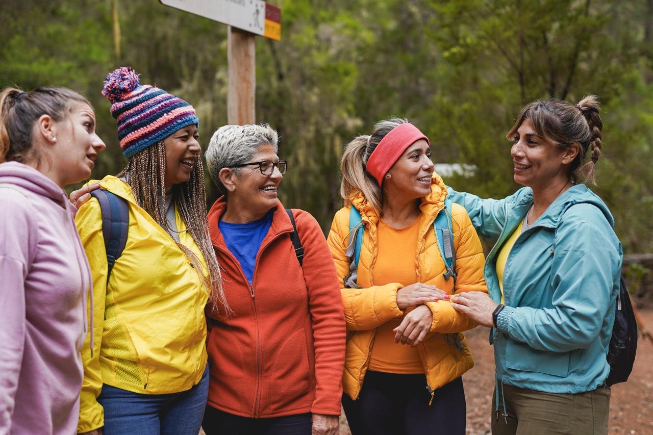 concetto di Come socializzare dopo i 50 anni. Gruppo di donne mature multietnco fa trekking