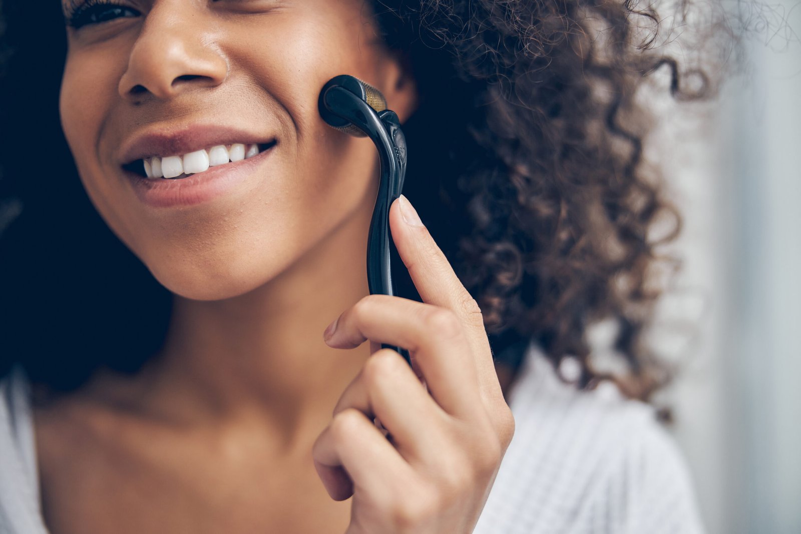 RAGAZZA AFRO PRATICA IL MICRONEEDLING TRADIZIONALE. CONCETTO DIFFFERNZA CON MICRONEEDLING LIQUIDO 