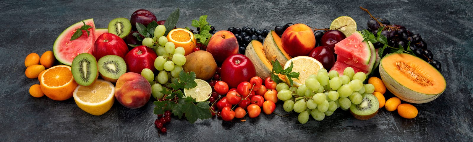 cibi che fanno bene alla pelle. Varietà di frutta fresca su sfondo scuro. Concetto di cibo biologico, panorama.