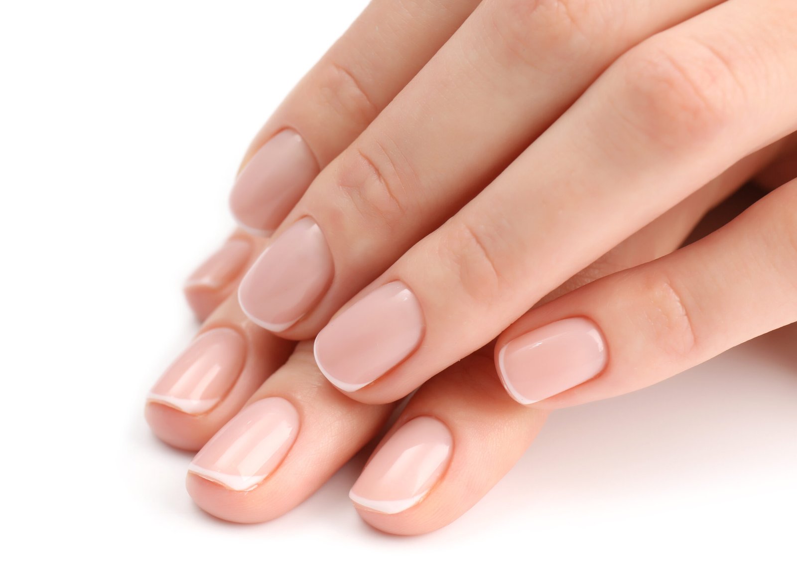 Mani di donna con una manicure naturale per unghie corte impeccabile, isolate su sfondo bianco.