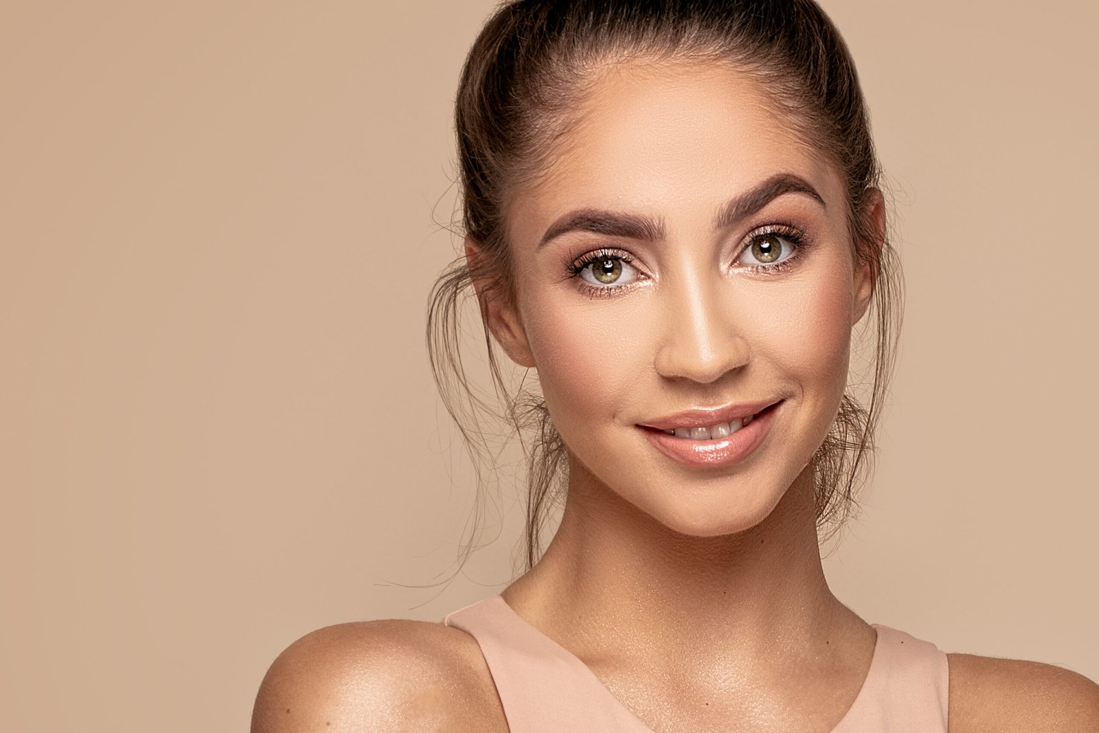Bellissima giovane donna, il suo viso, la sua pelle. Giovane ragazza sorridente e naturale. Ritratto di una donna bruna con grandi occhi che guarda in camera.