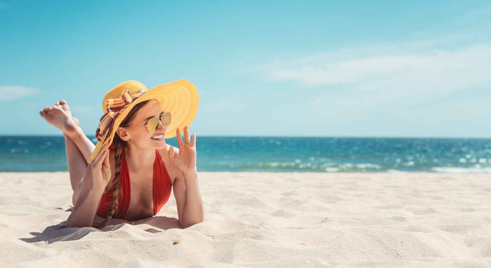 Una donna si gode le vacanze al mare prendendo il sole sulla spiaggia.