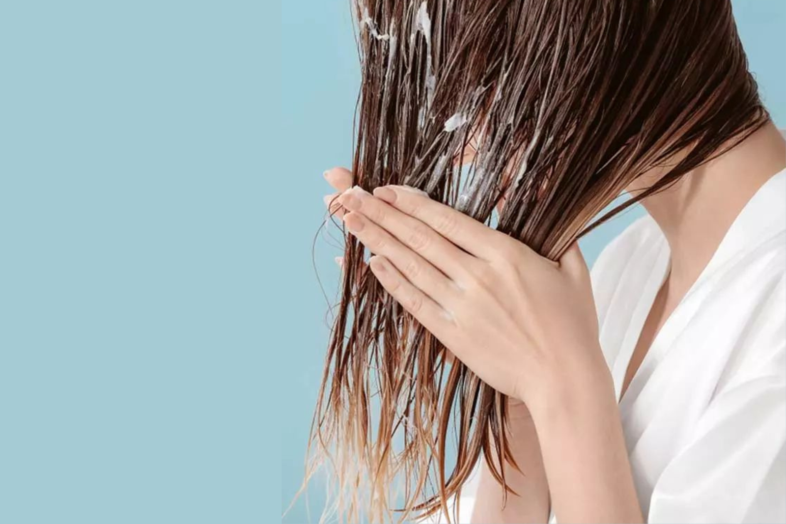 concetto di capelli mossi naturali:. donna applica crema per capelli . primo piano - sfondo isolato