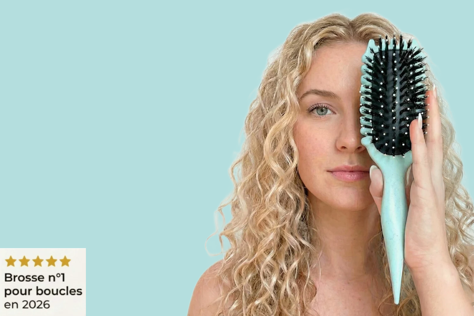concetto di capelli mossi naturali:. ragazza bionda guarda in camera tenendo davanti alviso laspazzola per fare i capelli mossi