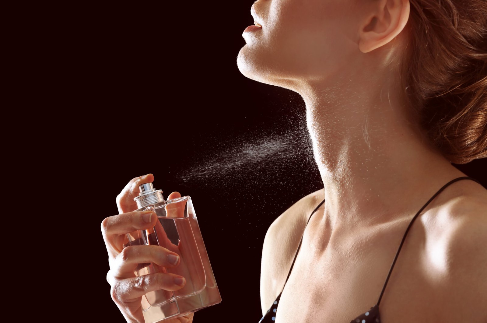 Concetto come usare la vaselina per fare durare profumo. Donna si spruzza profumo sul collo