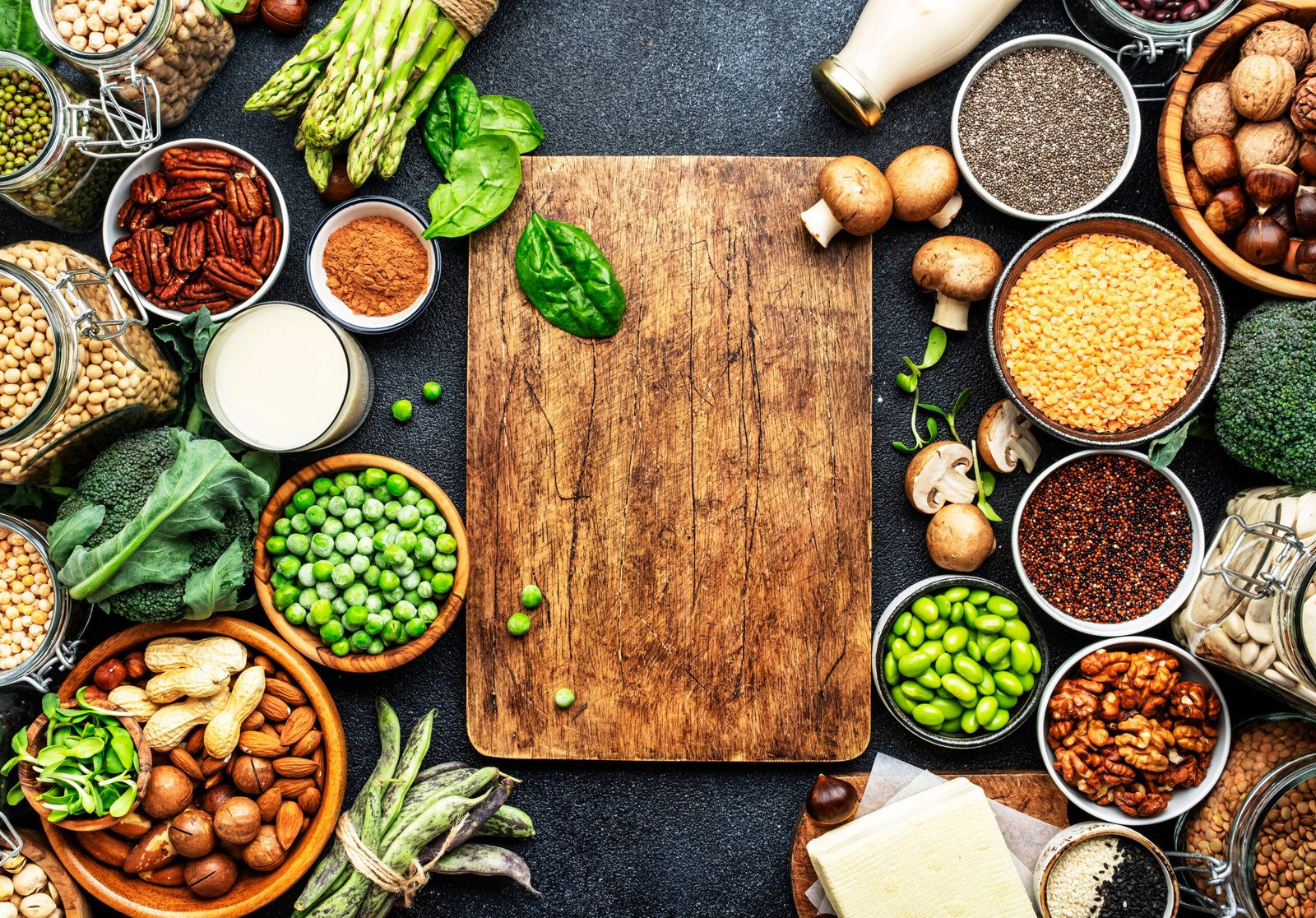 Proteine ​​vegane. Set completo di fonti alimentari vegetariane di origine vegetale. Alimentazione sana, ingredienti dietetici, come abbinare le proteine vegetali: legumi, fagioli, lenticchie, frutta secca, latte di soia e di mandorla, tofu, quinoa, semi di chia, verdure, spinaci, semi e germogli. Vista dall'alto