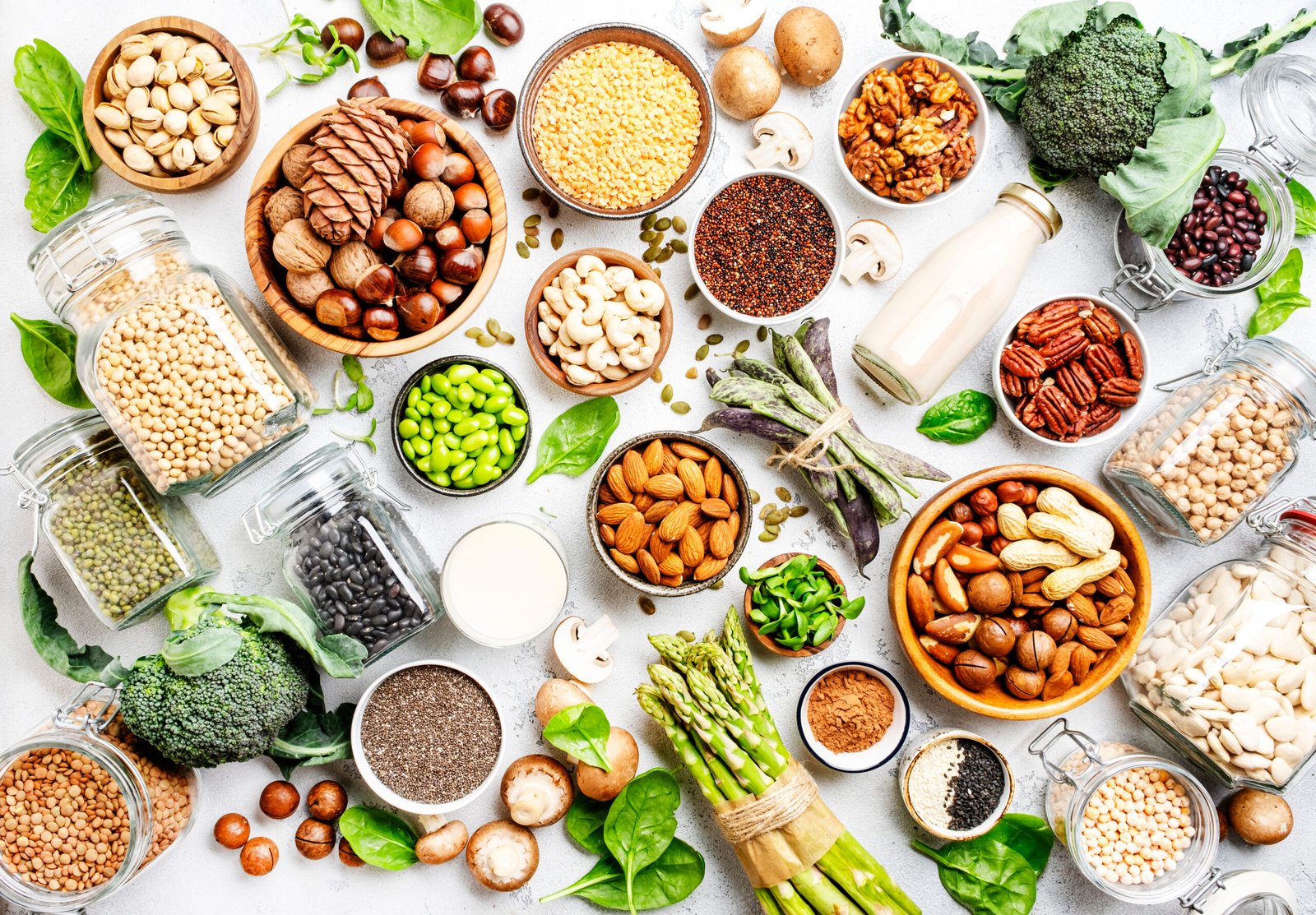 Proteine ​​vegane. Set completo di fonti alimentari vegetariane di origine vegetale. Alimentazione sana, ingredienti dietetici, come abbinare le proteine vegetali: legumi, fagioli, lenticchie, frutta secca, latte di soia e di mandorla, tofu, quinoa, semi di chia, verdure, spinaci, semi e germogli. Vista dall'alto