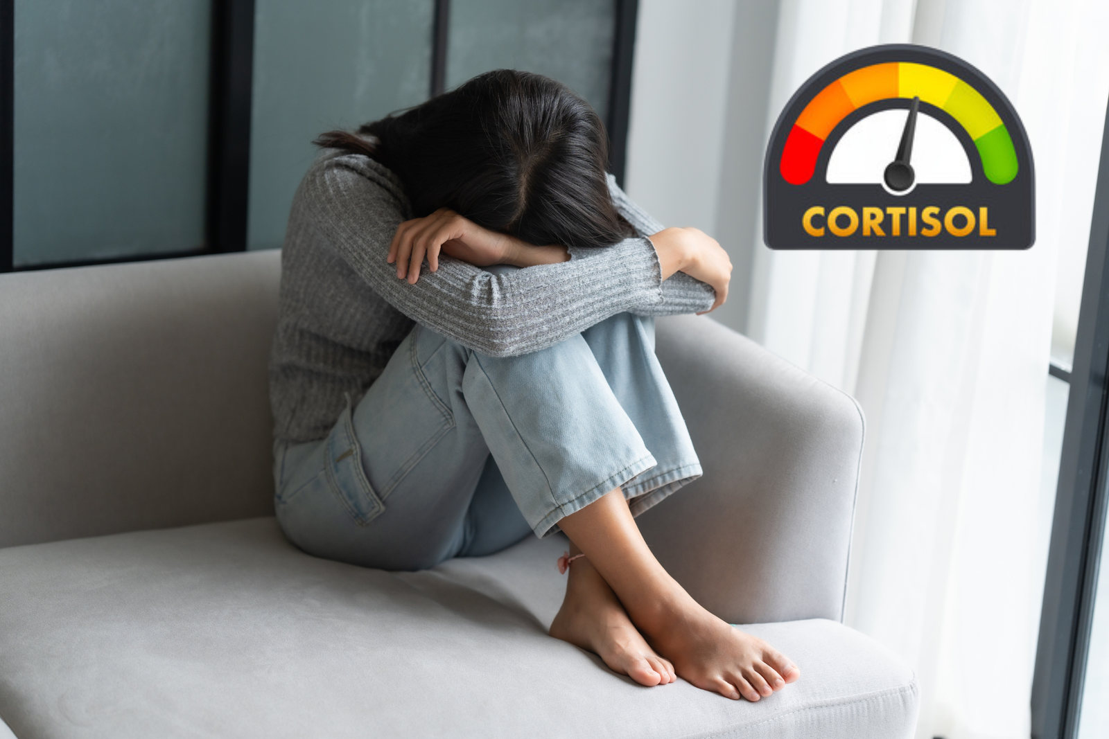 immagine di donna triste o stressata sul divano. Posa la testa sulle ginocchia e raccoglie le ginocchia al petto. Simbolo del cortisolo alto 